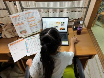 小学校低学年の授業風景　ローマ字表を見ながら一文字ずつ丁寧に入力をしています。はじめてのパソコン学習でも、集中して取り組む姿がとても頼もしいです。